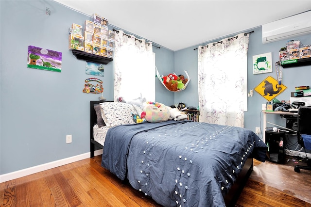 71 E Kissimee Rd, Lindenhurst, NY 11757 - bedroom with baseboards, wood finished floors, and a wall unit AC