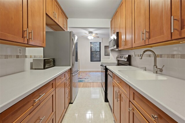 45 Overlook Ter Unit 5A, New York Manhattan, NY 10033 - kitchen with a ceiling fan, tasteful backsplash, a sink, brown cabinetry, and stainless steel appliances