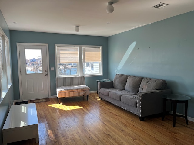 living area featuring wood finished floors, visible vents, and a healthy amount of sunlight