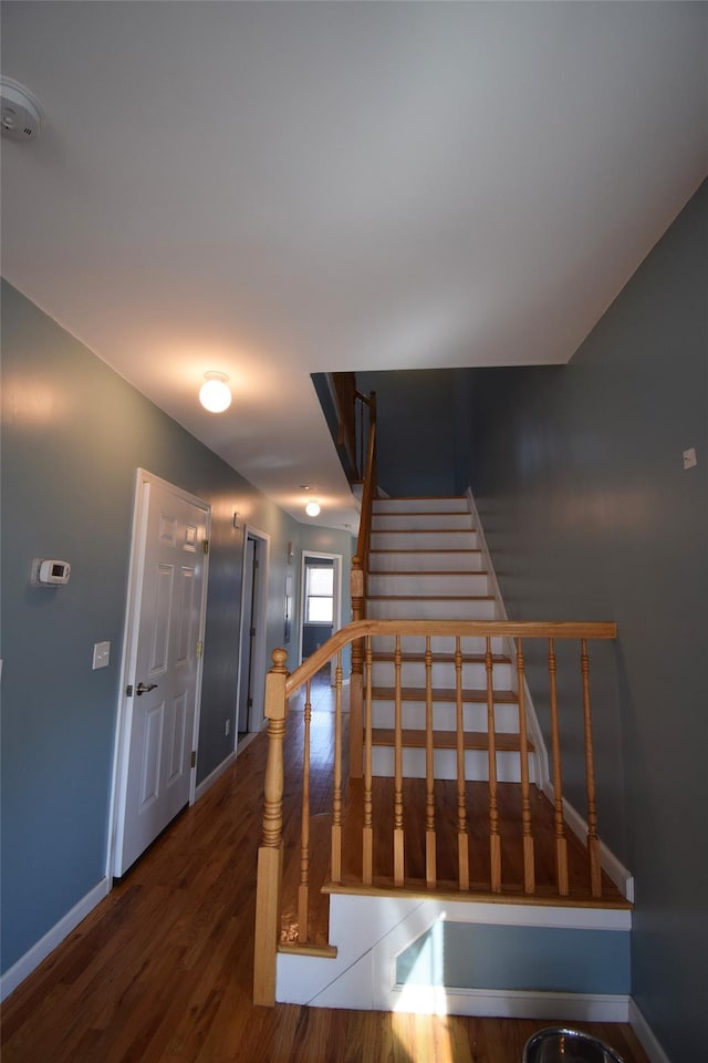 stairs featuring wood finished floors and baseboards