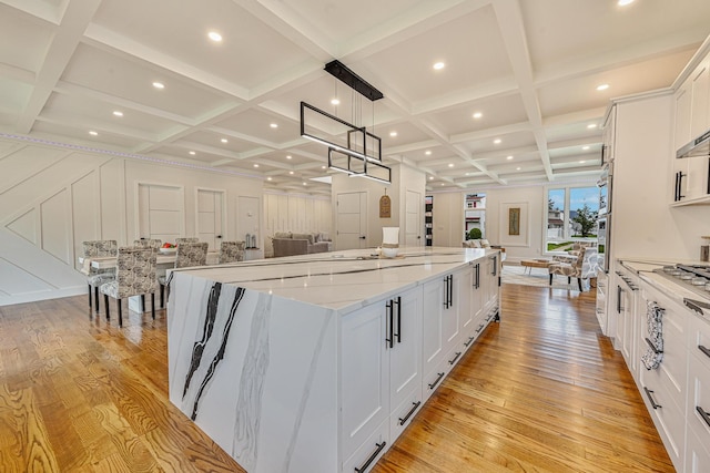 296 Division Ave, Hicksville, NY 11801 - kitchen with coffered ceiling, light wood-style floors, open floor plan, a large island, and white cabinetry