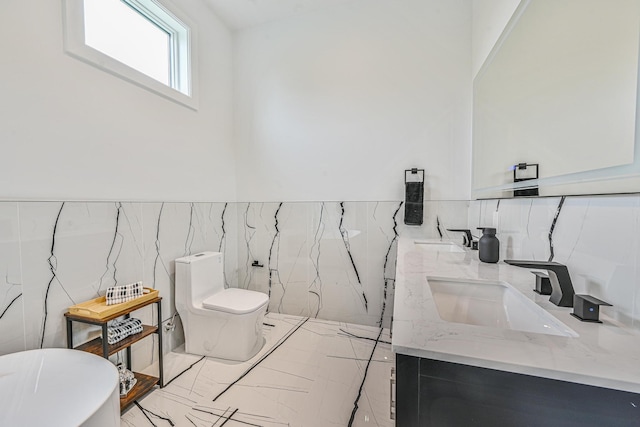 296 Division Ave, Hicksville, NY 11801 - full bathroom with double vanity, a freestanding tub, tile walls, marble finish flooring, and toilet