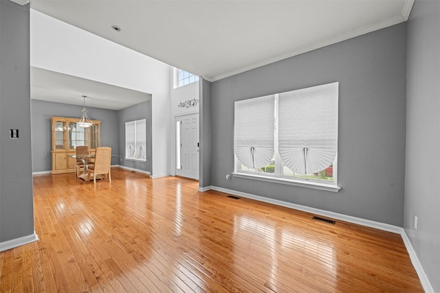 2066 Independence Dr, New Windsor, NY 12553 - unfurnished living room featuring wood-type flooring, healthy amount of natural light, and crown molding