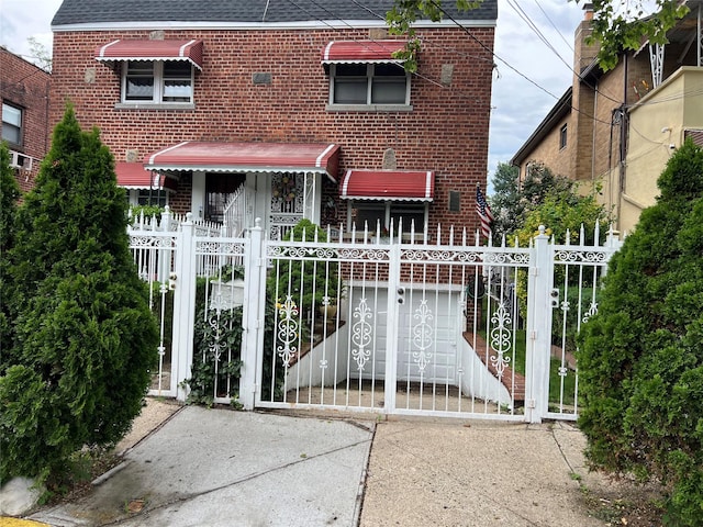 2737 Tenbroeck Ave, Bronx, NY 10469 - back of house with brick siding, a gate, a fenced front yard, and roof with shingles