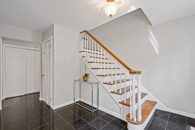 staircase featuring baseboards and granite finish floor