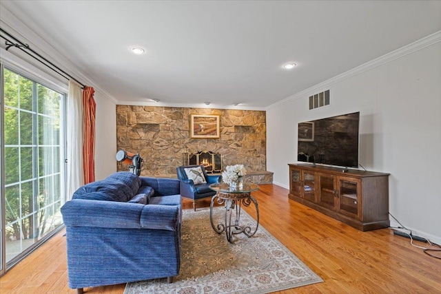 living room featuring crown molding, a fireplace, recessed lighting, wood finished floors, and visible vents
