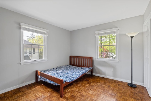 bedroom with baseboards and multiple windows