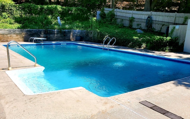 611 High St, Port Jefferson, NY 11777 - view of pool with a patio area, a fenced backyard, and a diving board