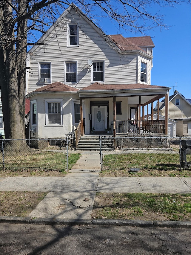 view of front of house featuring stucco siding, a fenced front yard, and covered porch