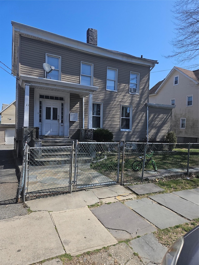 view of front of home featuring a chimney, a gate, and a fenced front yard