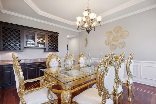 dining space with crown molding, a chandelier, a dry bar, and dark wood-type flooring