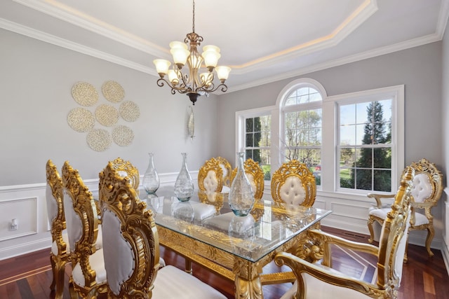 dining room with a notable chandelier, ornamental molding, and wood finished floors