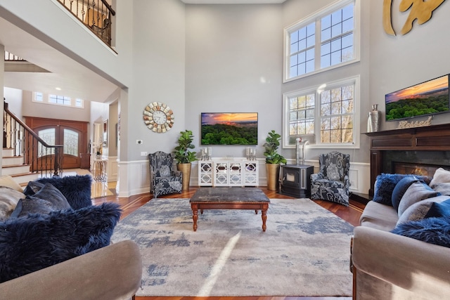 living room featuring plenty of natural light, a high ceiling, stairway, and wood finished floors