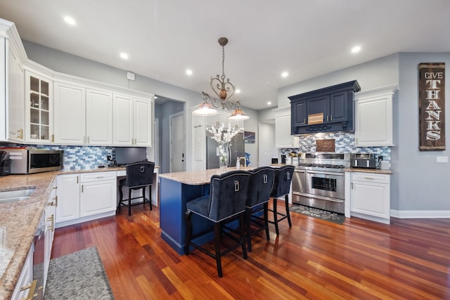 kitchen featuring appliances with stainless steel finishes, tasteful backsplash, a kitchen island, and white cabinetry