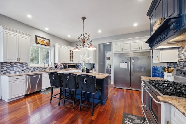 kitchen featuring white cabinetry, appliances with stainless steel finishes, dark wood-style floors, and light stone countertops