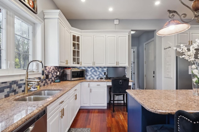 kitchen featuring a sink, stainless steel appliances, dark wood-style floors, and a wealth of natural light
