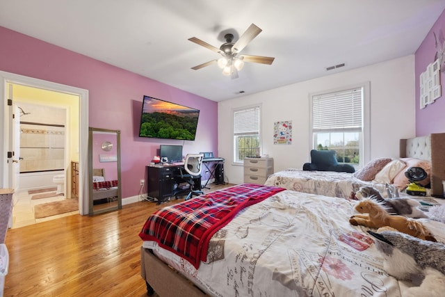 bedroom with connected bathroom, light wood-style floors, a ceiling fan, baseboards, and visible vents