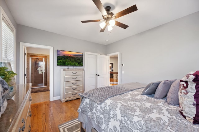 bedroom with a ceiling fan, baseboards, and light wood-style flooring