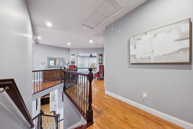 corridor featuring attic access, recessed lighting, baseboards, an upstairs landing, and wood finished floors