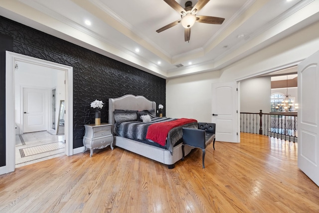 bedroom featuring crown molding, an inviting chandelier, light wood-style floors, and visible vents