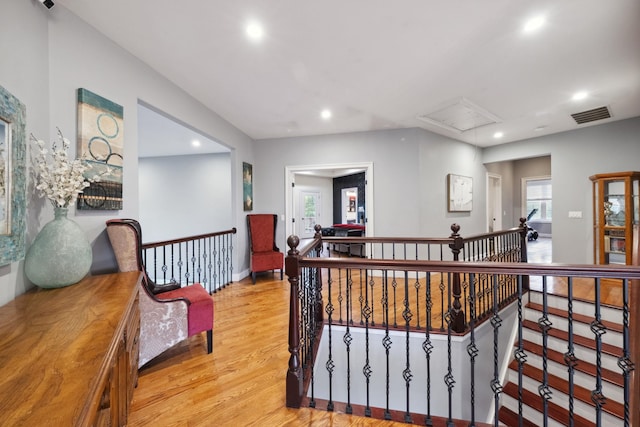 hall with visible vents, light wood-style floors, attic access, recessed lighting, and an upstairs landing