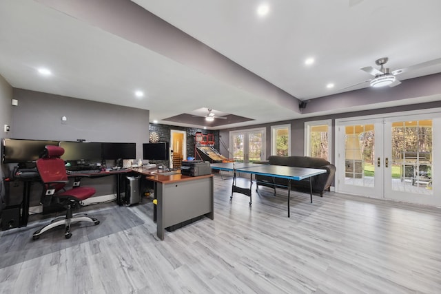 recreation room with french doors, a ceiling fan, a raised ceiling, recessed lighting, and light wood-style flooring