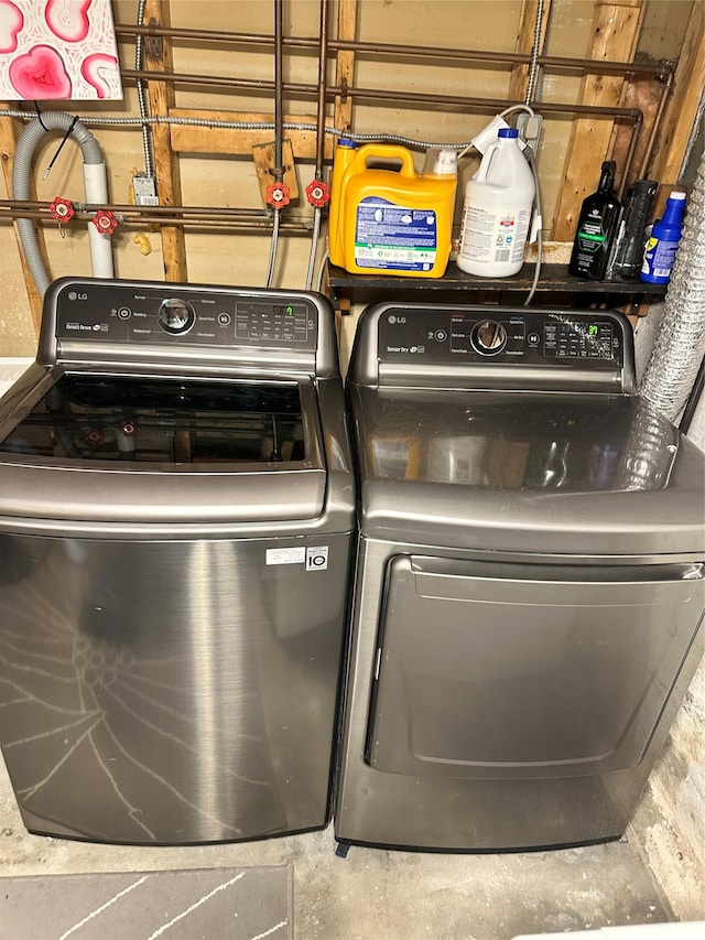 clothes washing area featuring washing machine and clothes dryer and laundry area