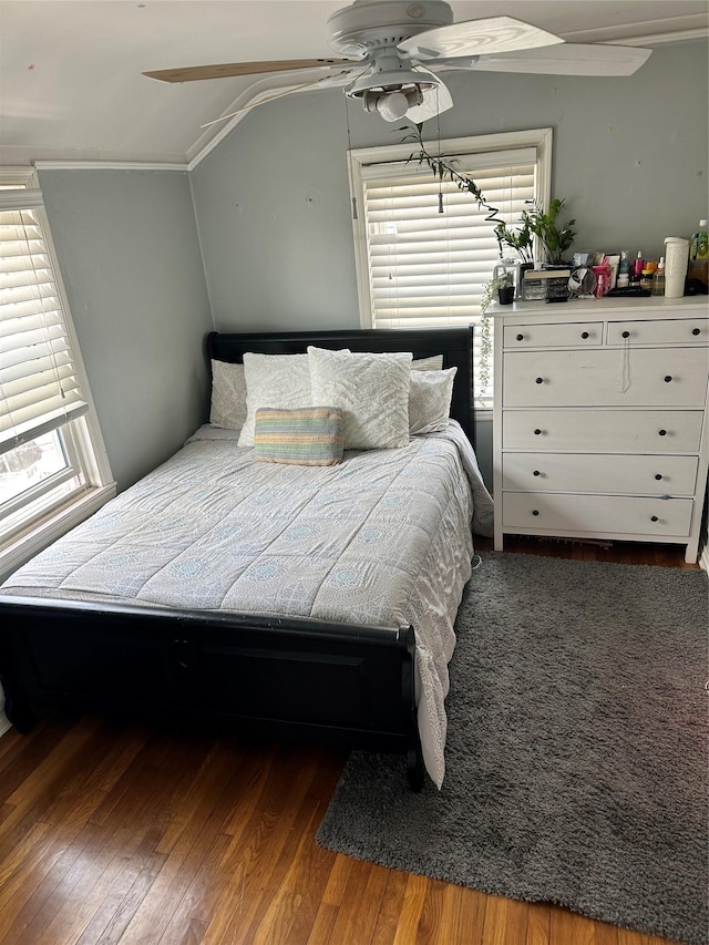 bedroom featuring a ceiling fan, ornamental molding, and dark wood-style floors