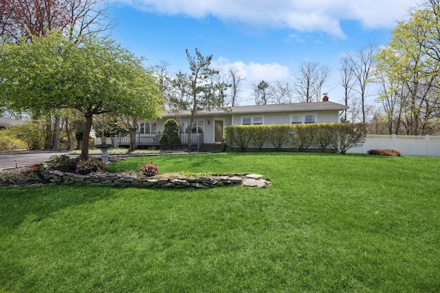 24 Linda Ln, East Moriches, NY 11940 - view of front facade featuring a chimney, a front yard, and fence