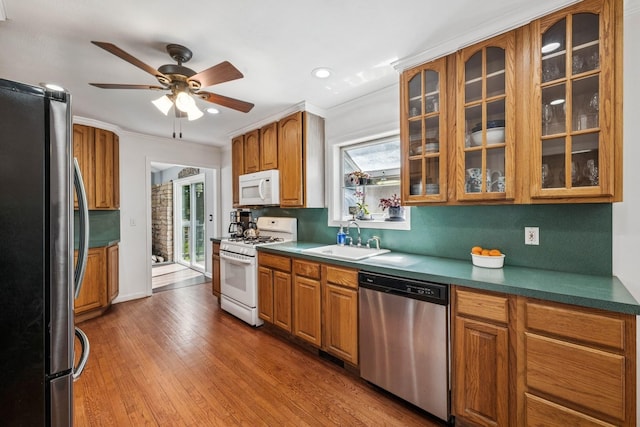 24 Linda Ln, East Moriches, NY 11940 - kitchen with wood finished floors, a sink, brown cabinetry, ceiling fan, and stainless steel appliances