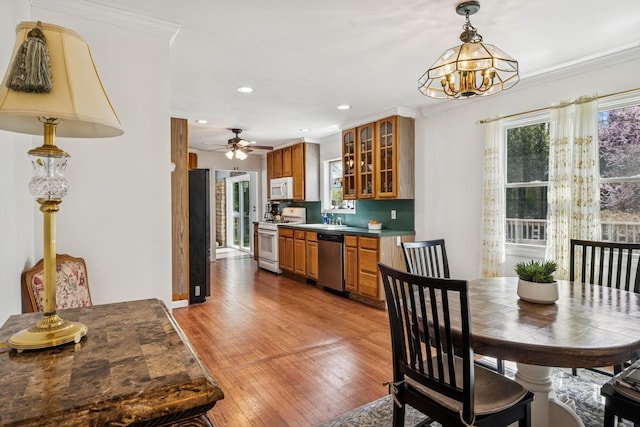 24 Linda Ln, East Moriches, NY 11940 - dining space featuring ornamental molding, ceiling fan with notable chandelier, light wood finished floors, and recessed lighting