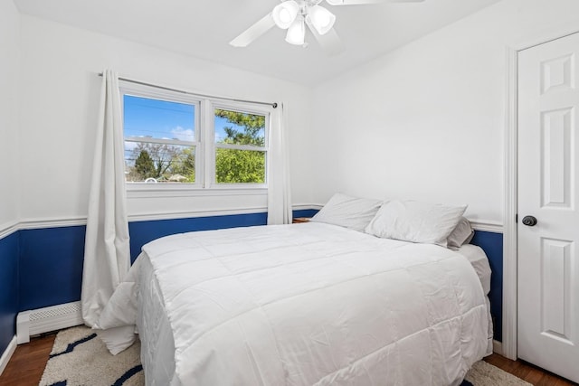 24 Linda Ln, East Moriches, NY 11940 - bedroom featuring a baseboard heating unit, baseboards, a ceiling fan, and wood finished floors