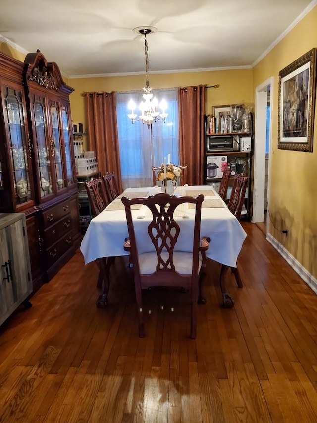 dining area with crown molding, a notable chandelier, and hardwood / wood-style flooring