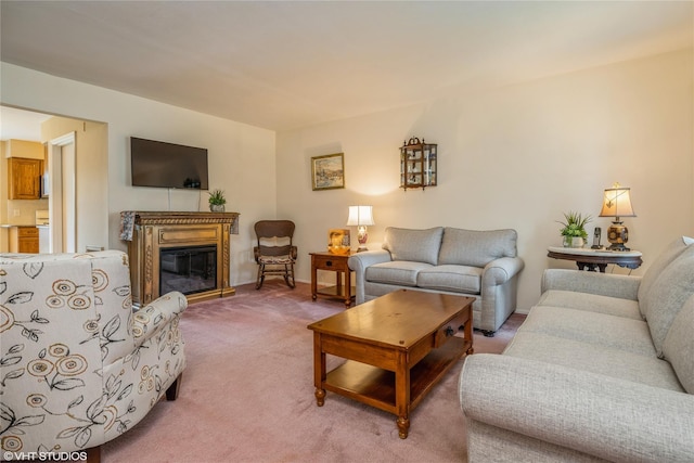 living area featuring light carpet, baseboards, and a glass covered fireplace