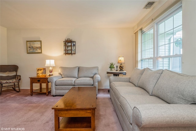 living room featuring visible vents, baseboards, and light carpet