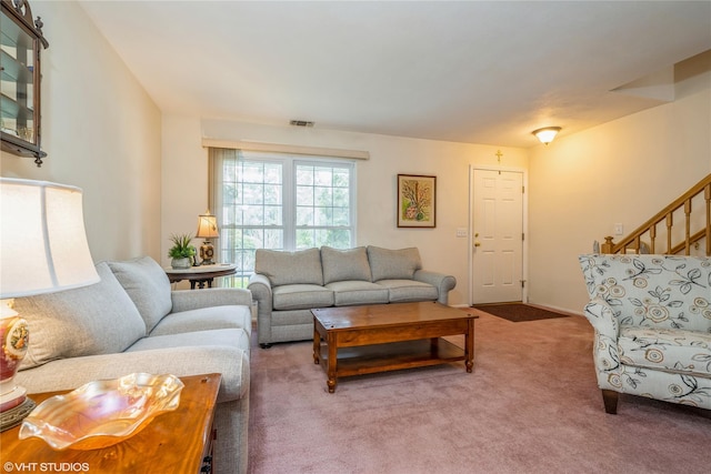 carpeted living area with stairs and visible vents