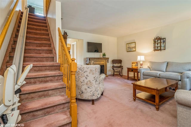 living area featuring light colored carpet, a fireplace, and stairway