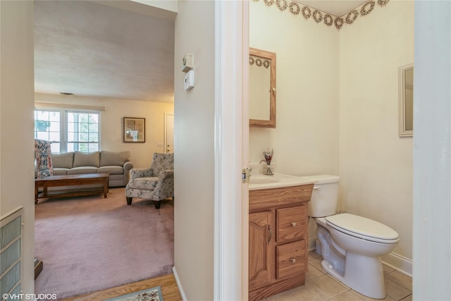 bathroom with toilet, vanity, and tile patterned floors