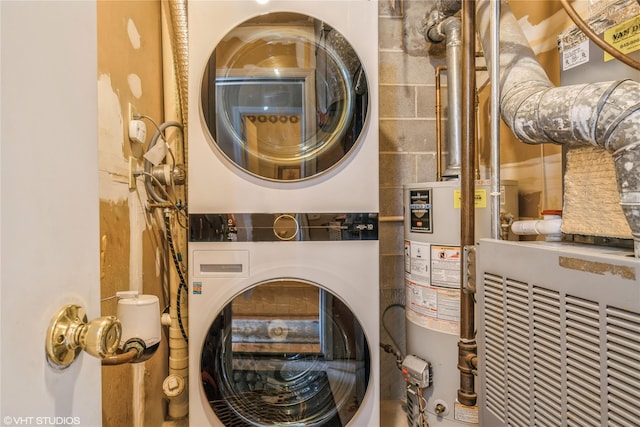 clothes washing area with water heater, stacked washer / dryer, heating unit, and laundry area