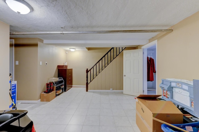67-54 Groton St, Forest Hills, NY 11375 - finished basement with light tile patterned floors, stairs, a textured ceiling, and baseboards