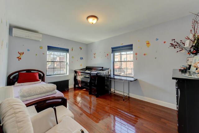 67-54 Groton St, Forest Hills, NY 11375 - bedroom with hardwood / wood-style flooring, radiator, an AC wall unit, and multiple windows