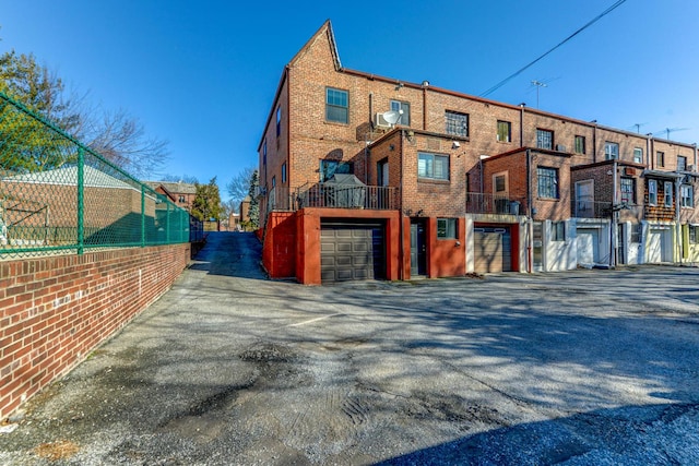 67-54 Groton St, Forest Hills, NY 11375 - exterior space featuring brick siding, an attached garage, aphalt driveway, and a residential view