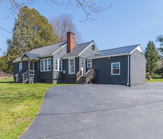ranch-style house with a chimney, a standing seam roof, and metal roof