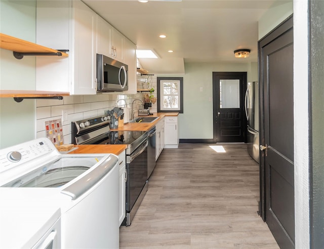 kitchen featuring white cabinets, stainless steel appliances, a sink, recessed lighting, and open shelves