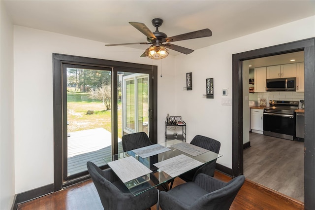 dining area with baseboards, a ceiling fan, and dark wood-type flooring