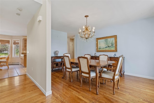 dining area featuring baseboards, light wood finished floors, a chandelier, and baseboard heating
