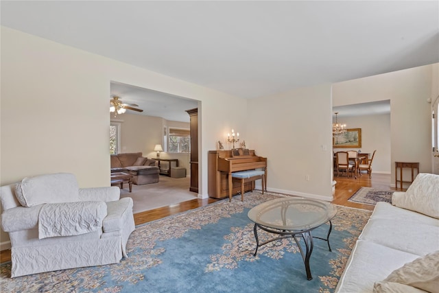 living room with baseboards, an inviting chandelier, and wood finished floors