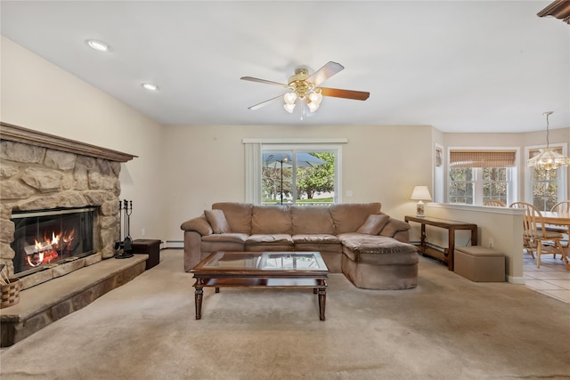 carpeted living area with a baseboard radiator, ceiling fan with notable chandelier, a healthy amount of sunlight, and a fireplace