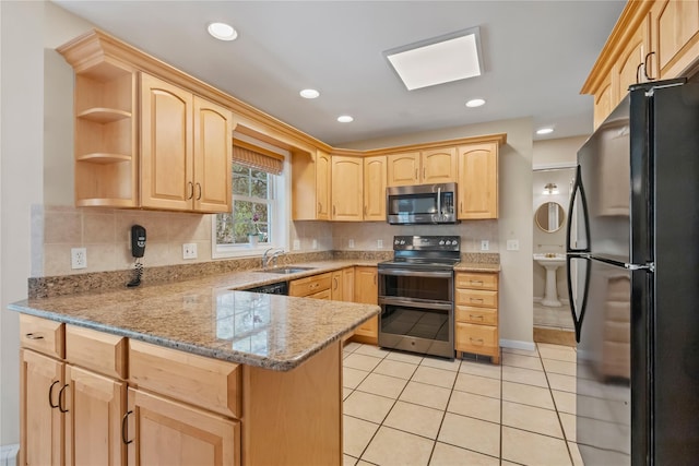 kitchen with light tile patterned flooring, a sink, light brown cabinets, stainless steel appliances, and a peninsula