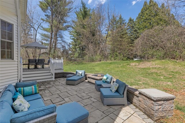 view of patio / terrace featuring a deck and an outdoor living space with a fire pit
